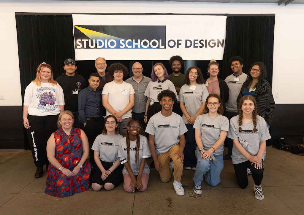 group of students in front of a sign that says "Studio School of Design"