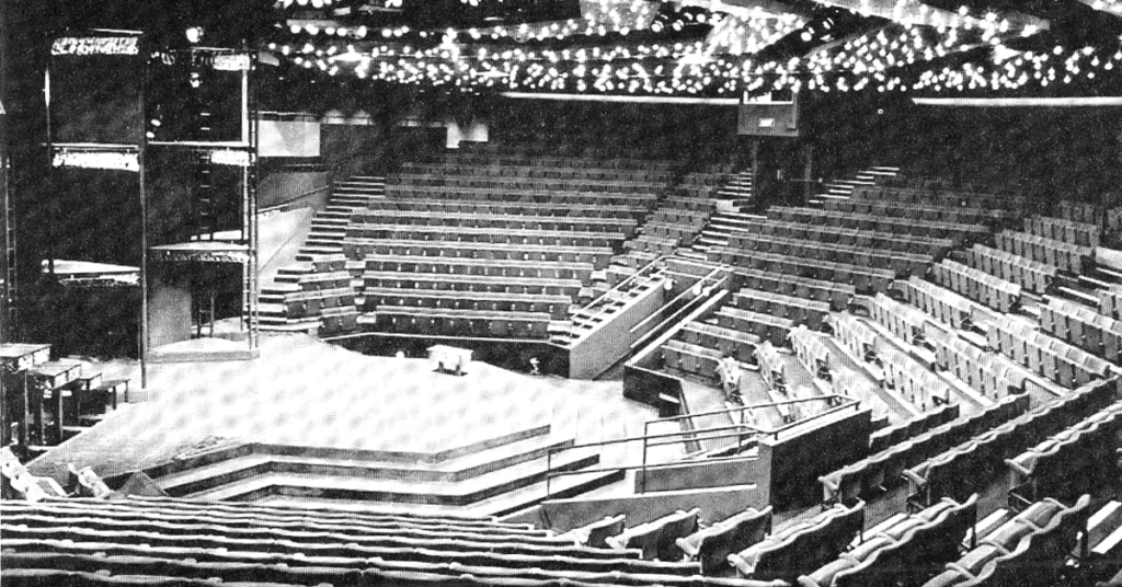 a black and white photo of a large thrust stage and seating